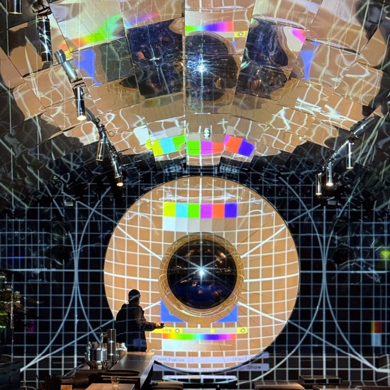 RGpro | passgenaue Lösungen Futuristischer Raum mit leuchtenden, geometrischen Mustern und einer zentralen, runden Struktur.