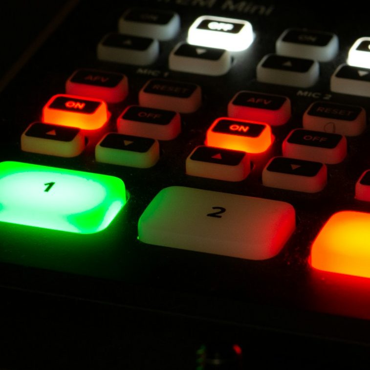 AV-Steuerung für Video- und Medientechnik bei Events Tastatur mit beleuchteten Tasten in verschiedenen Farben, darunter ein grüner und roter Knopf.